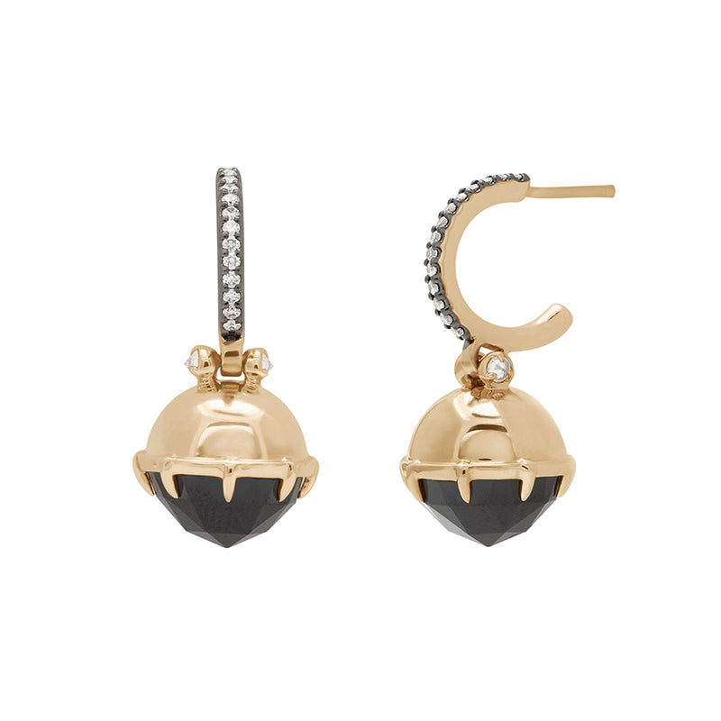 A pair of drop hoops with a black spinel hanging from them with white diamond accents on either side set in yellow gold with white diamond pave set in black rhodium one earring angled.