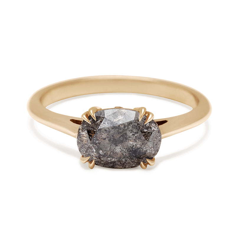 An east/west solitaire ring with an oval grey diamond stone set in yellow gold.