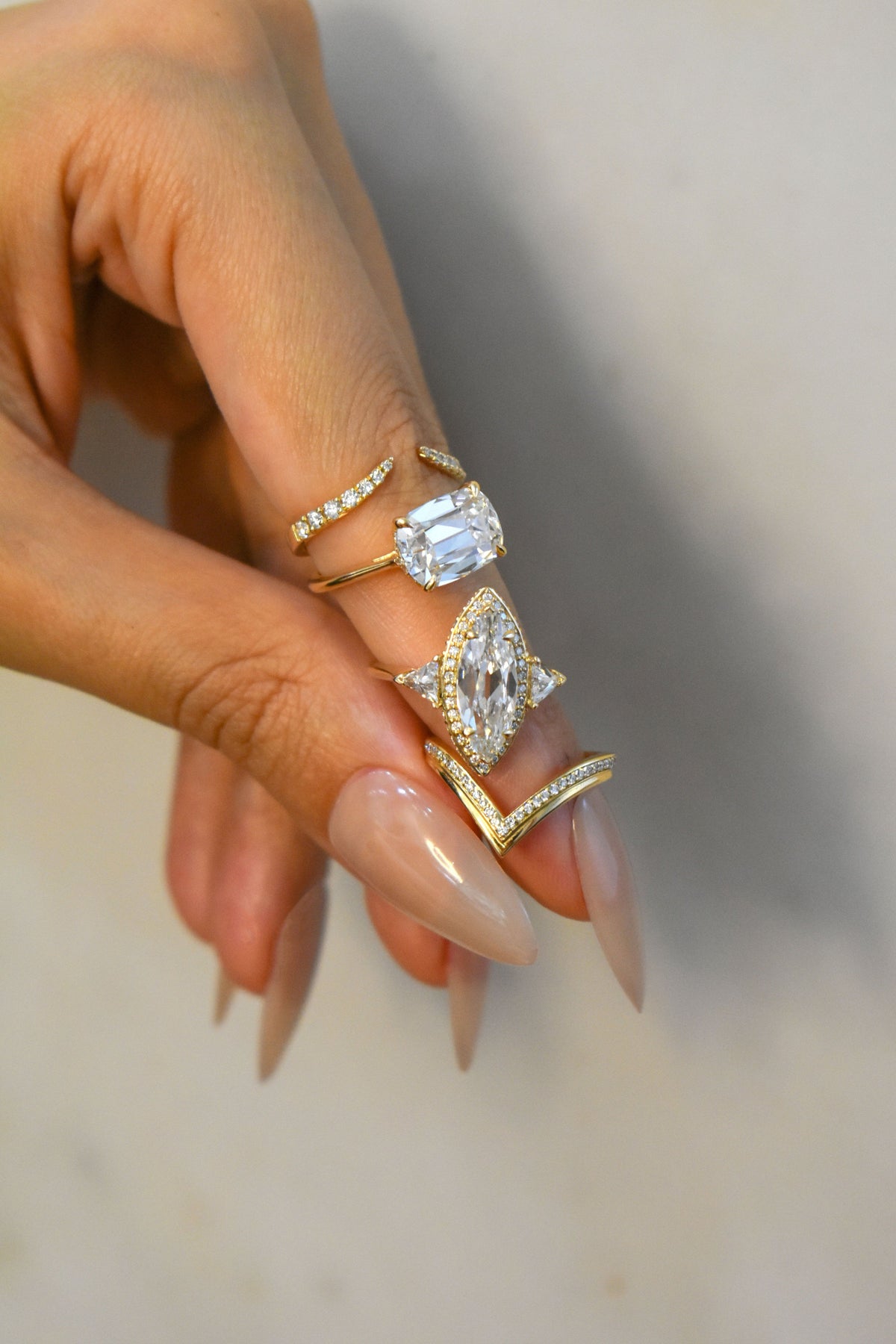 Female hand wearing and holding a few lab grown diamond rings