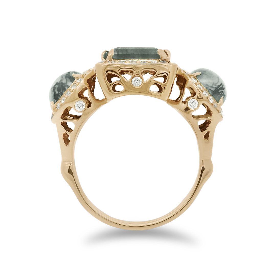 Side profile of a moss agate ring encircled with white diamond pavé set in 14kt yellow gold. 