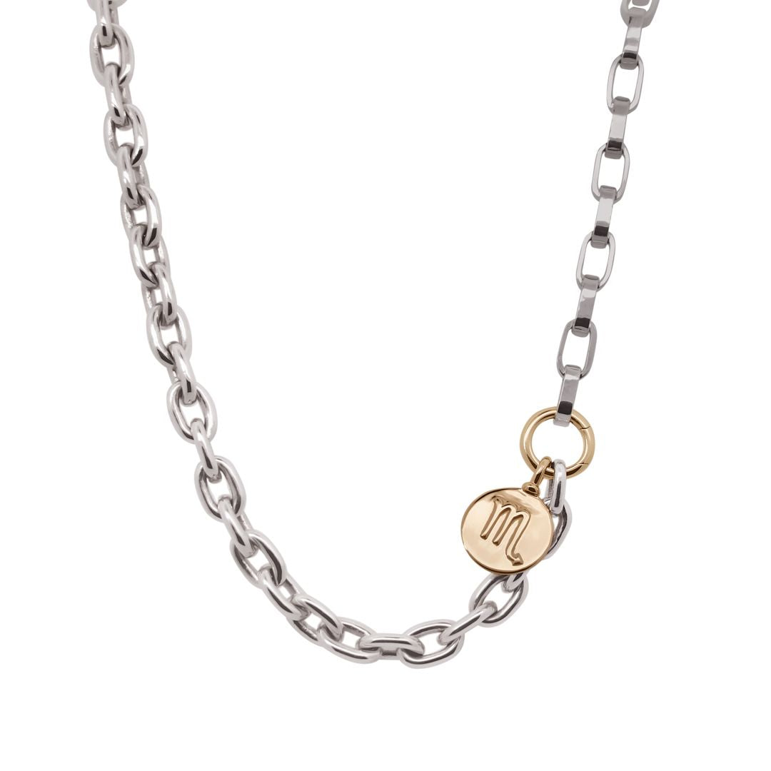 Silver chain necklace with a gold tag featuring a monogram on a white background