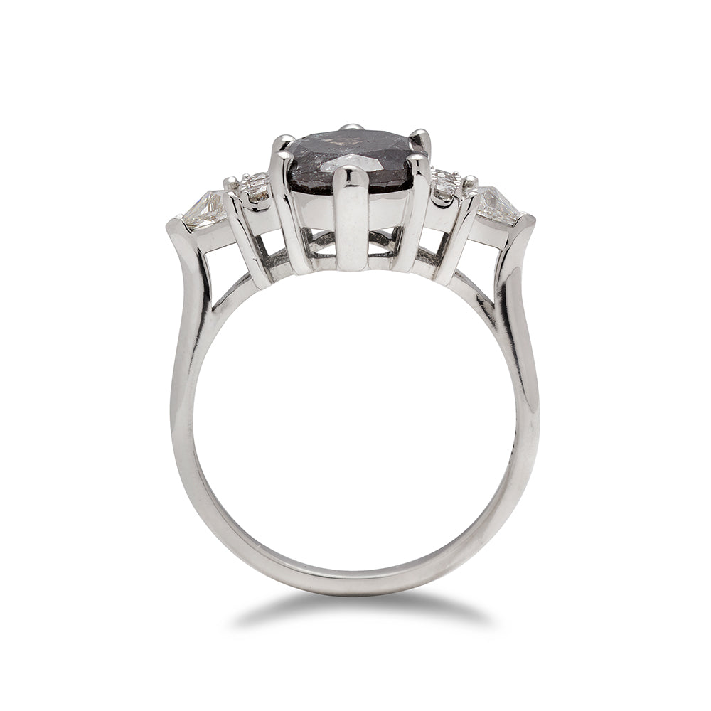 Side view of an oval shaped 2.00ct grey diamond center stone ring with three round white diamonds on either and two white diamond trillions on the outer edges of each side set in white gold.