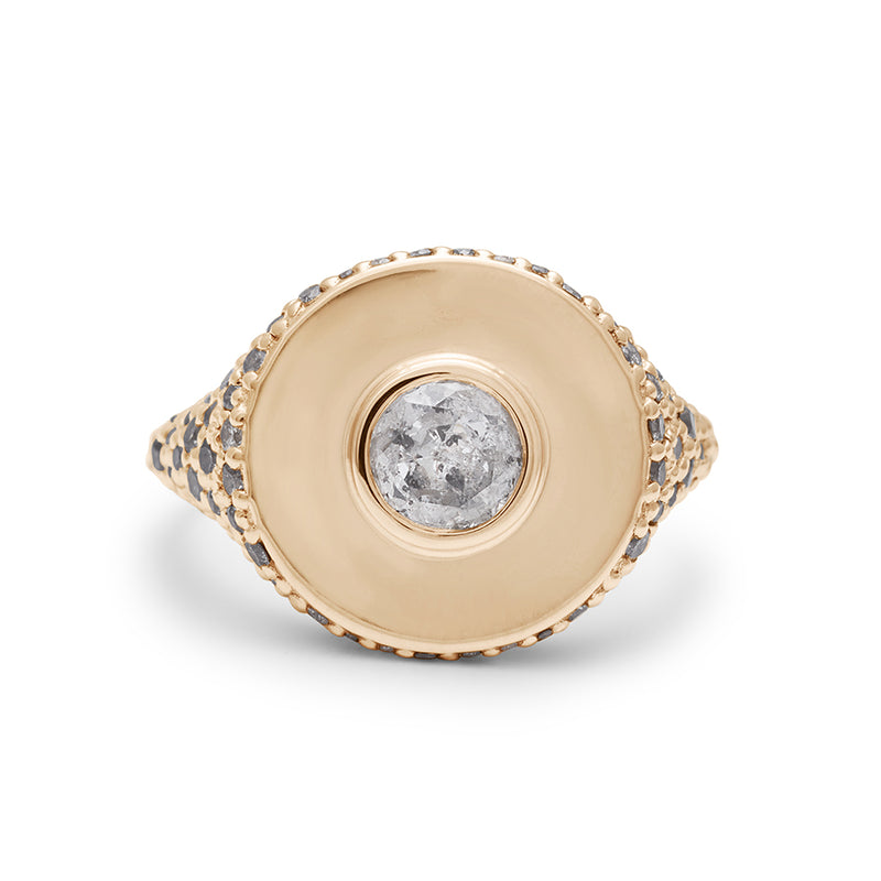 Front view of a round grey diamond bezel set in a signet style ring with white and grey diamond pave down the sides of the band set in yellow gold.