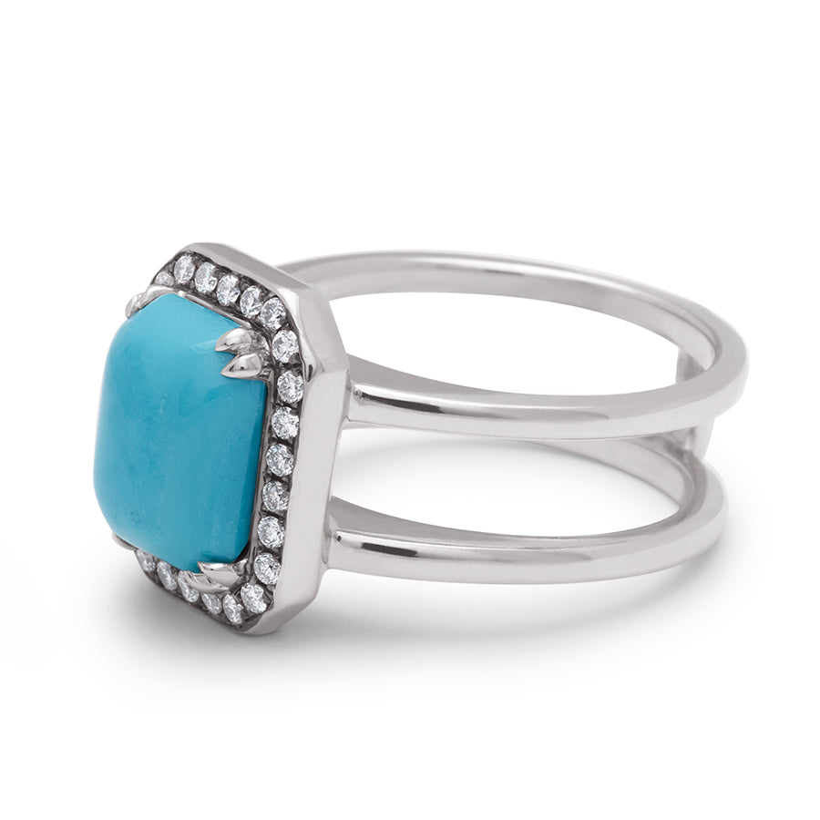 Angled view of a double banded engagement ring with a emerald shape turquoise surrounded by a white diamond halo set in platinum.
