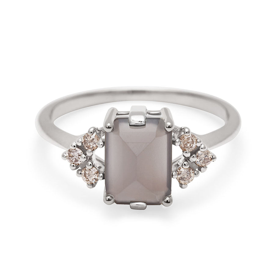 A ring with an emerald cut grey moonstone center with three round champagne diamonds on either side in arrow shape, set in white gold., White Gold
