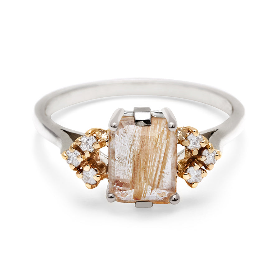 A ring with an emerald cut golden rutilated quartz center with three round white diamonds on either side in arrow shape, set in white gold., White Gold