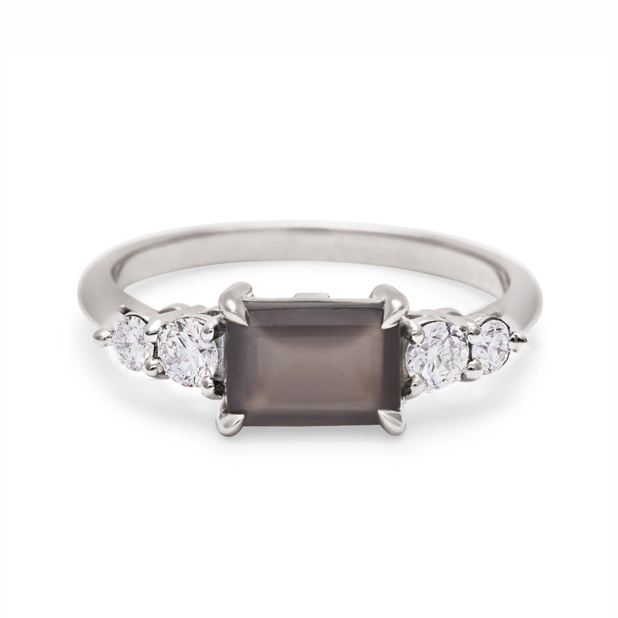 A ring with an emerald shaped grey moonstone center stone with two round white diamonds on either side set in white gold., White Gold