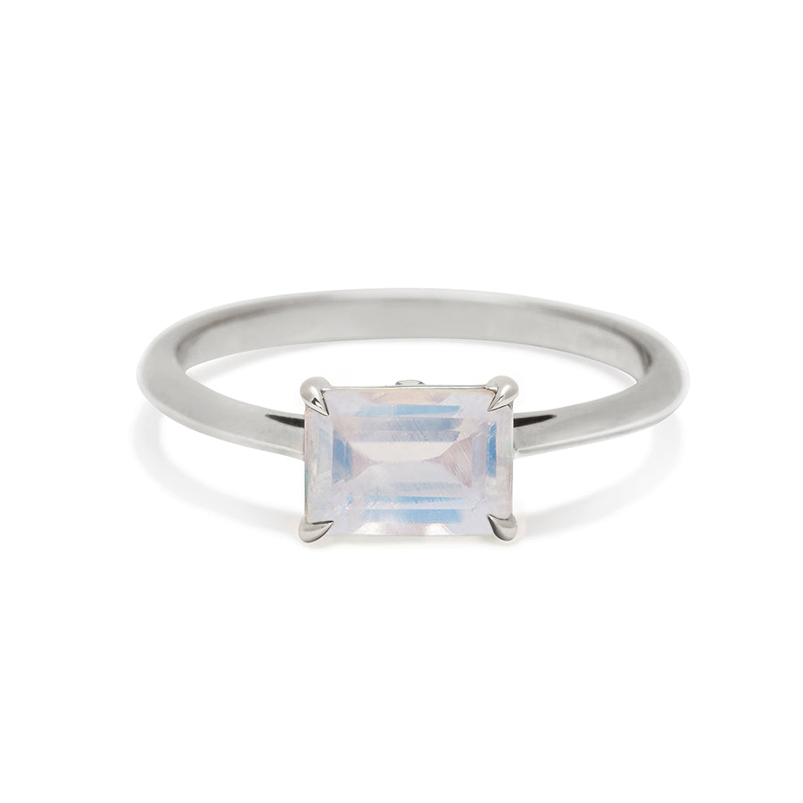 An east/west solitaire ring with an emerald shape rainbow moonstone set in white gold., White Gold