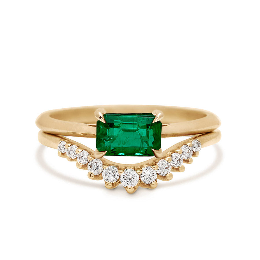 An east/west solitaire ring with an emerald shape green emerald stone set in yellow gold stacked above a white diamond nesting band., Yellow Gold, Rose Gold, White Gold