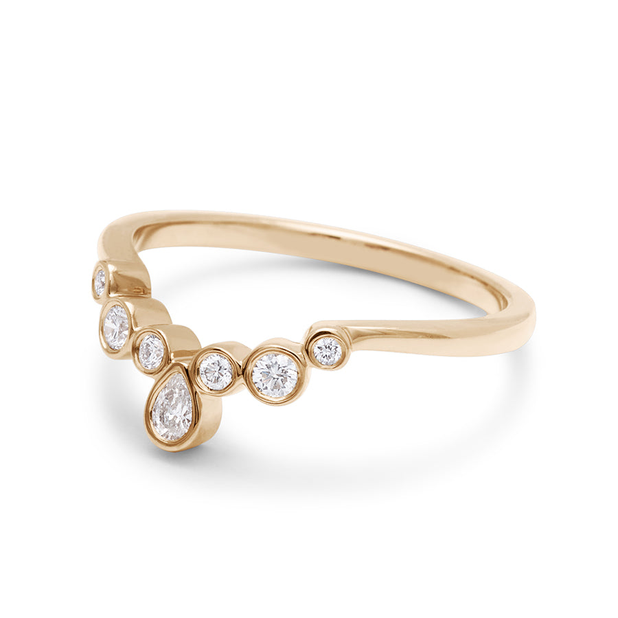 Angled view of a band with bezel set white diamonds in ascending size set in yellow gold., Yellow Gold