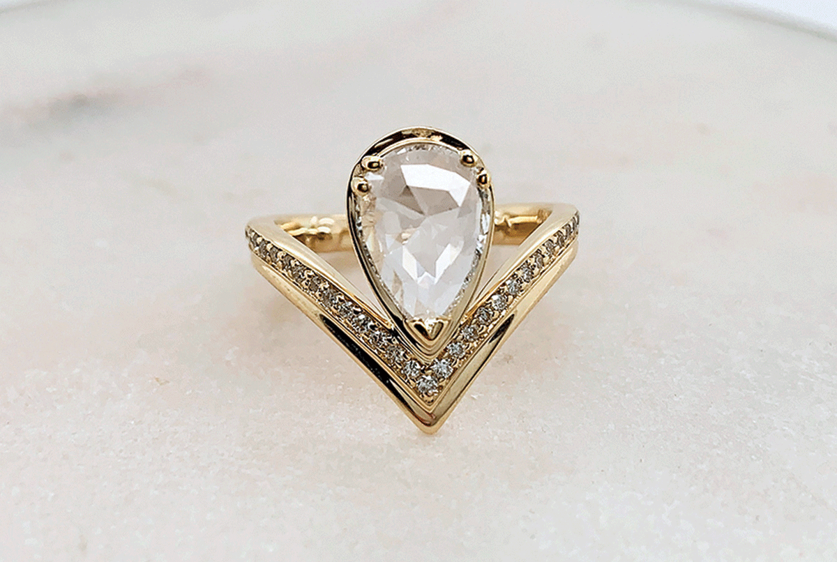 A custom engagement ring by Anna Sheffield featuring a large rose cut pear shape.