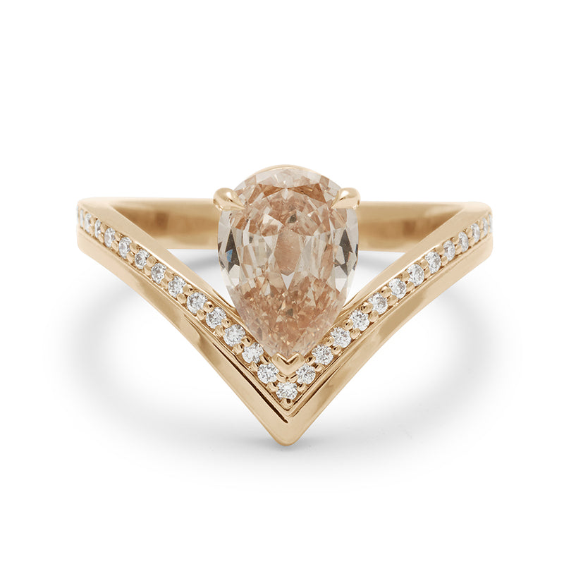 A pear champagne diamond set on top of a chrysalis band with white diamond pave set in yellow gold.