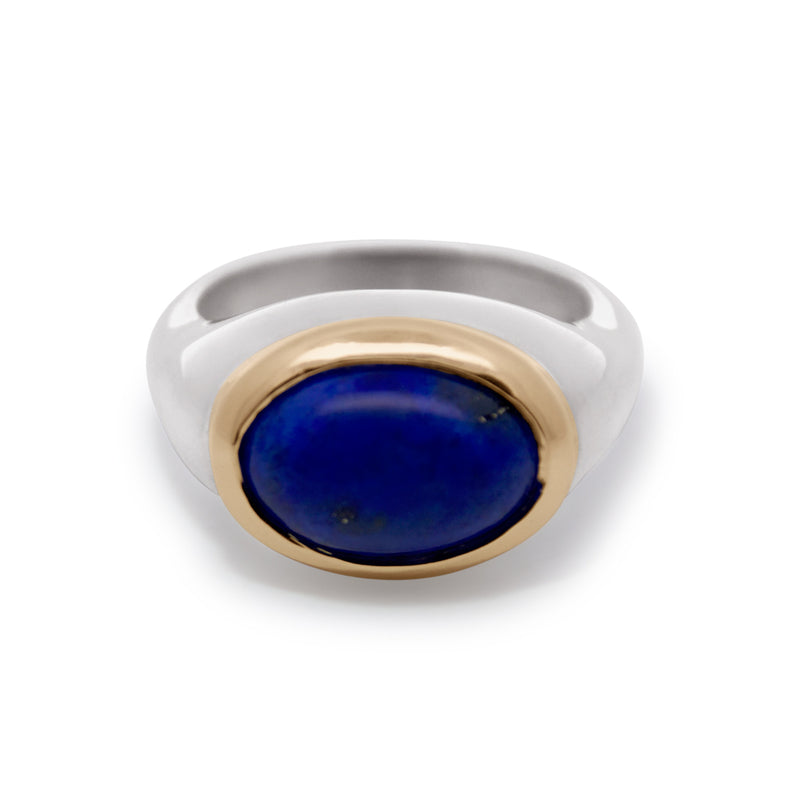 Ring with blue stone and gold and silver band on white background