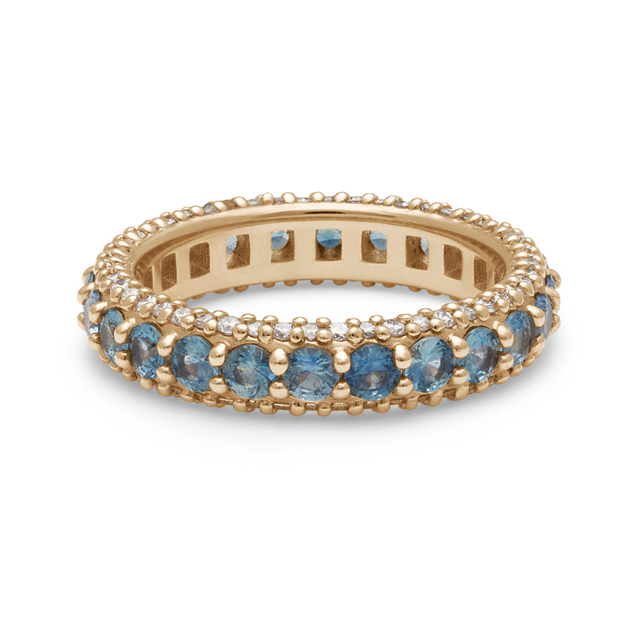 A band with round Montana sapphires set in eternity around a yellow gold band with white diamond pave accents on both top and bottom of the band.