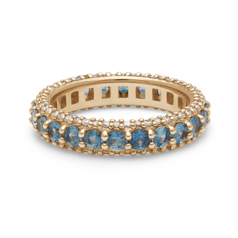 A band with round Montana sapphires set in eternity around a yellow gold band with white diamond pave accents on both top and bottom of the band.