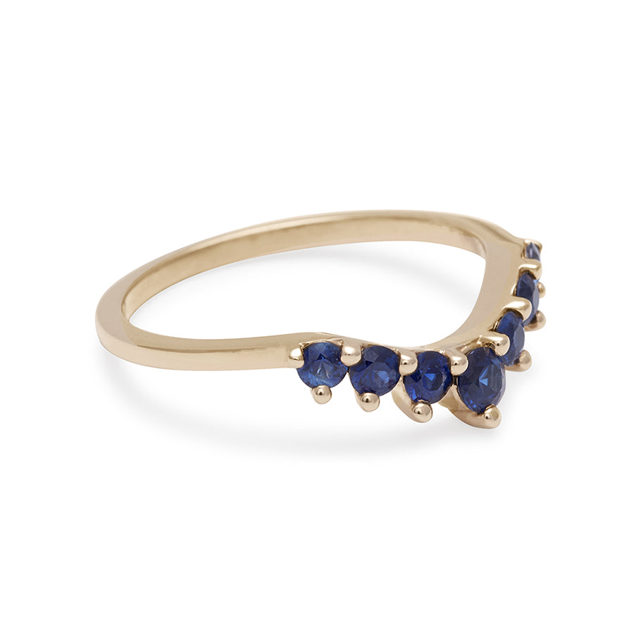 Side view of a curved 7 sapphire band set in yellow gold.