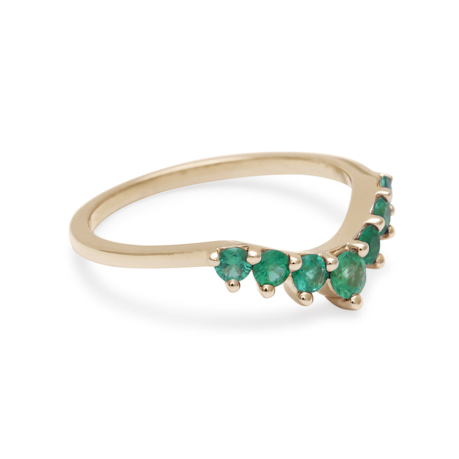 Side view of a curved 7 emerald band set in yellow gold.