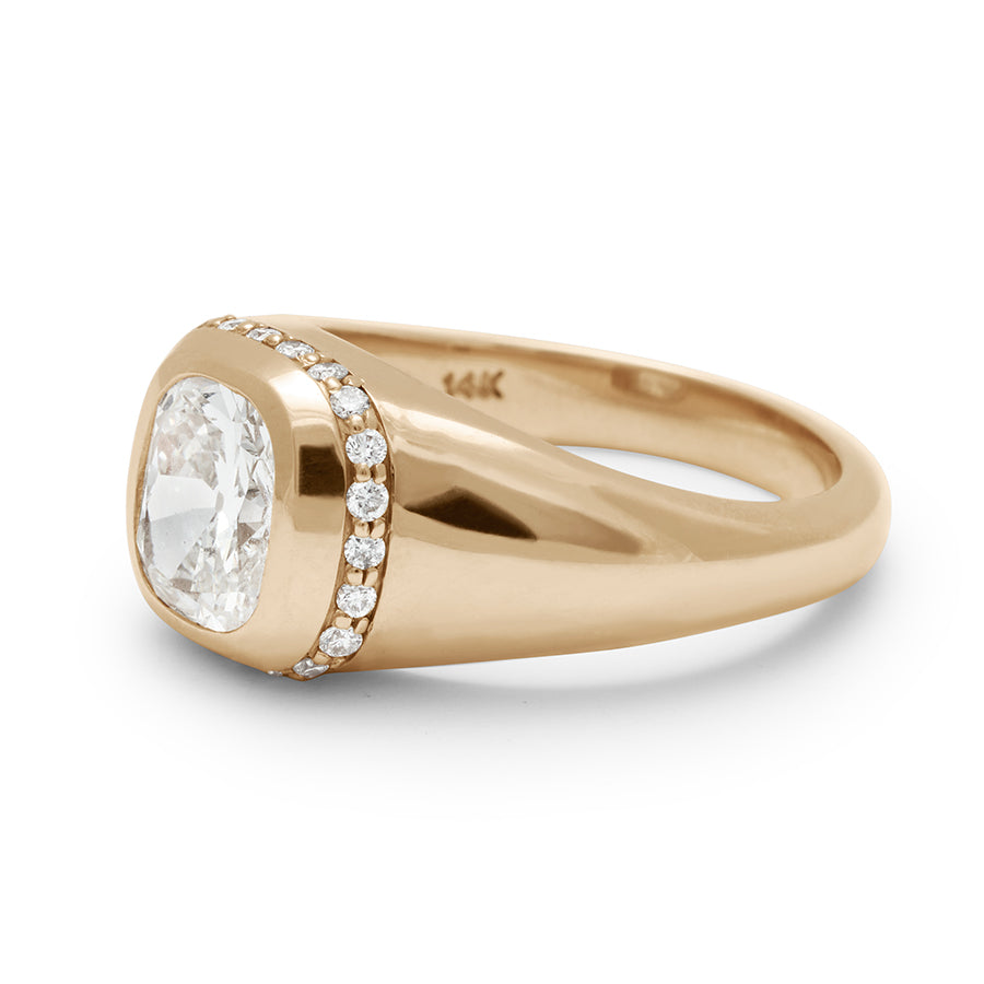Angled view of a cushion cut lab white diamond stone set in a signet style with a white diamond pave halo set in yellow gold.