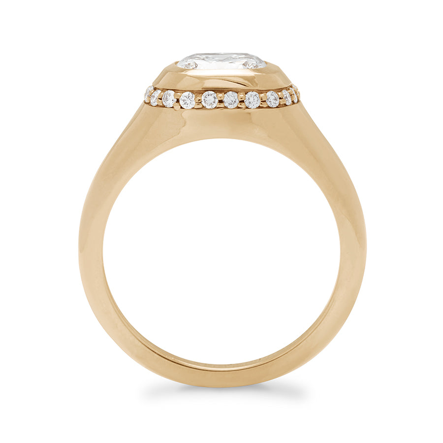 Side view of a cushion cut lab white diamond stone set in a signet style with a white diamond pave halo set in yellow gold.