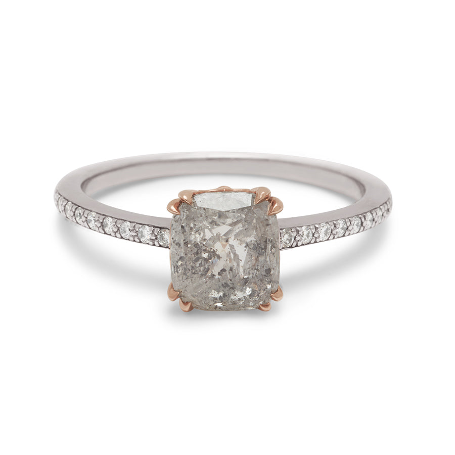 A solitaire ring with a cushion cut grey diamond set in a rose gold basket with white diamond pave on the white gold band.