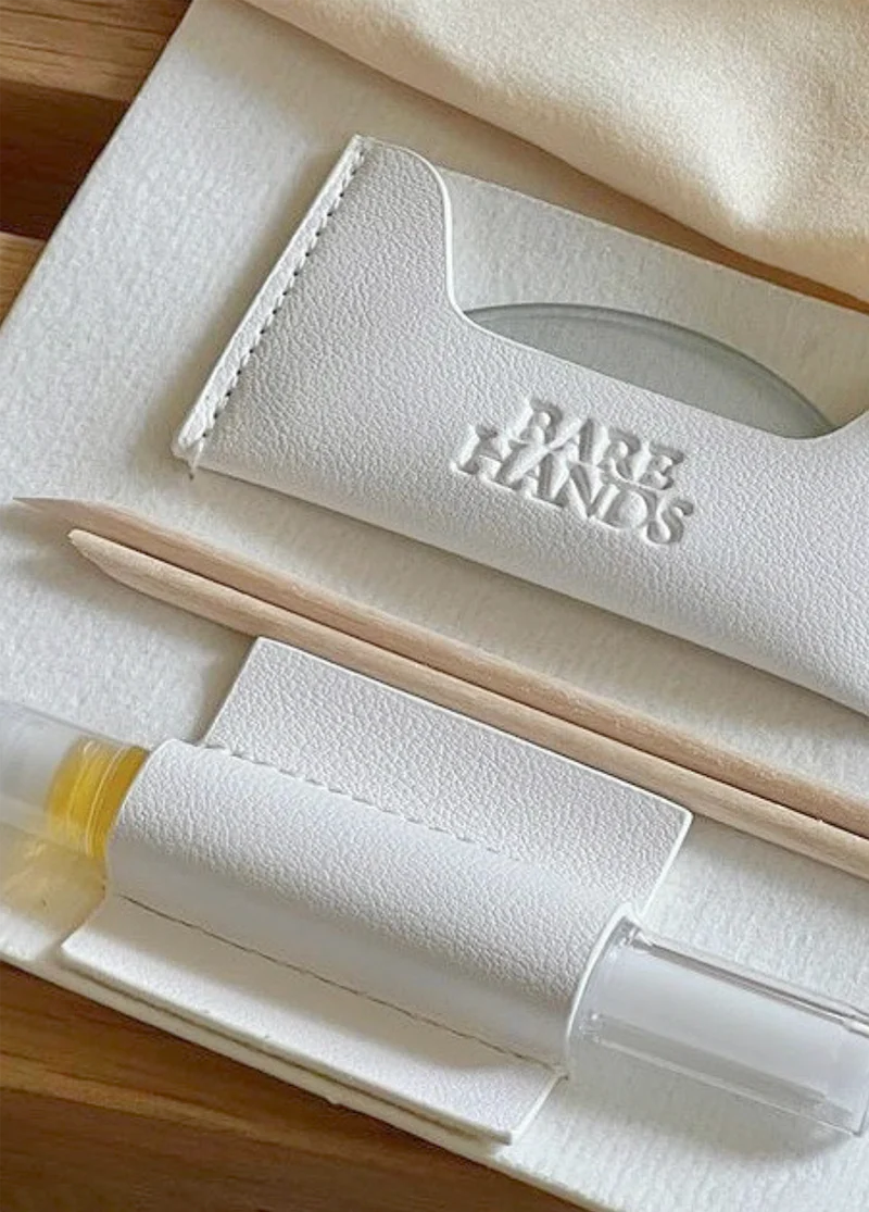 Set of skincare tools with 'Bare Hands' branding on a wooden surface