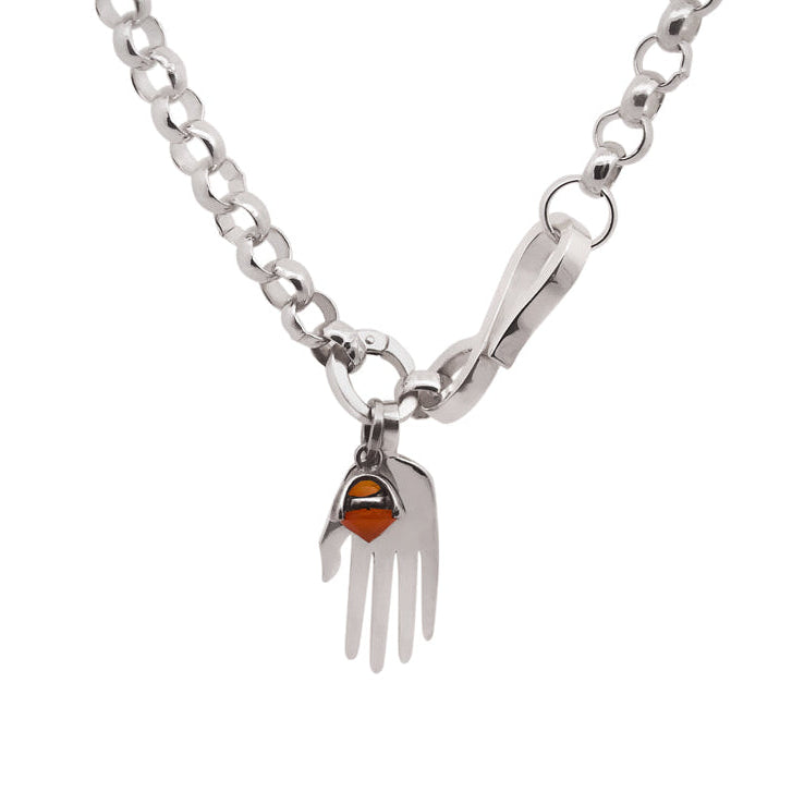 Silver rolo chain necklace with a silver hand charm and an orange carnelian gemstone charm set in silver on a white background