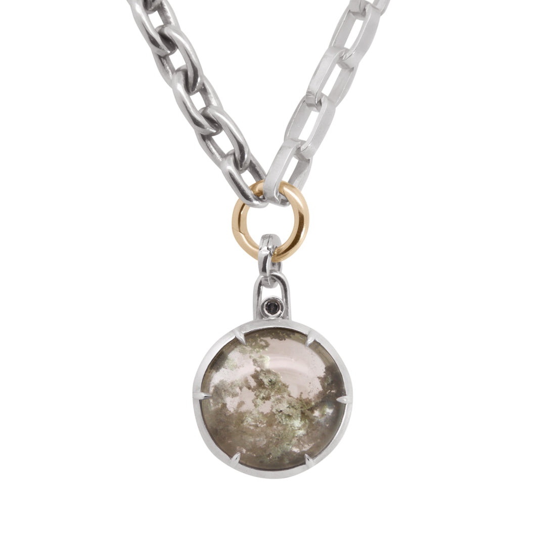 Silver chain with yellow gold O ring with a round greyish garden quartz pendant on a white background