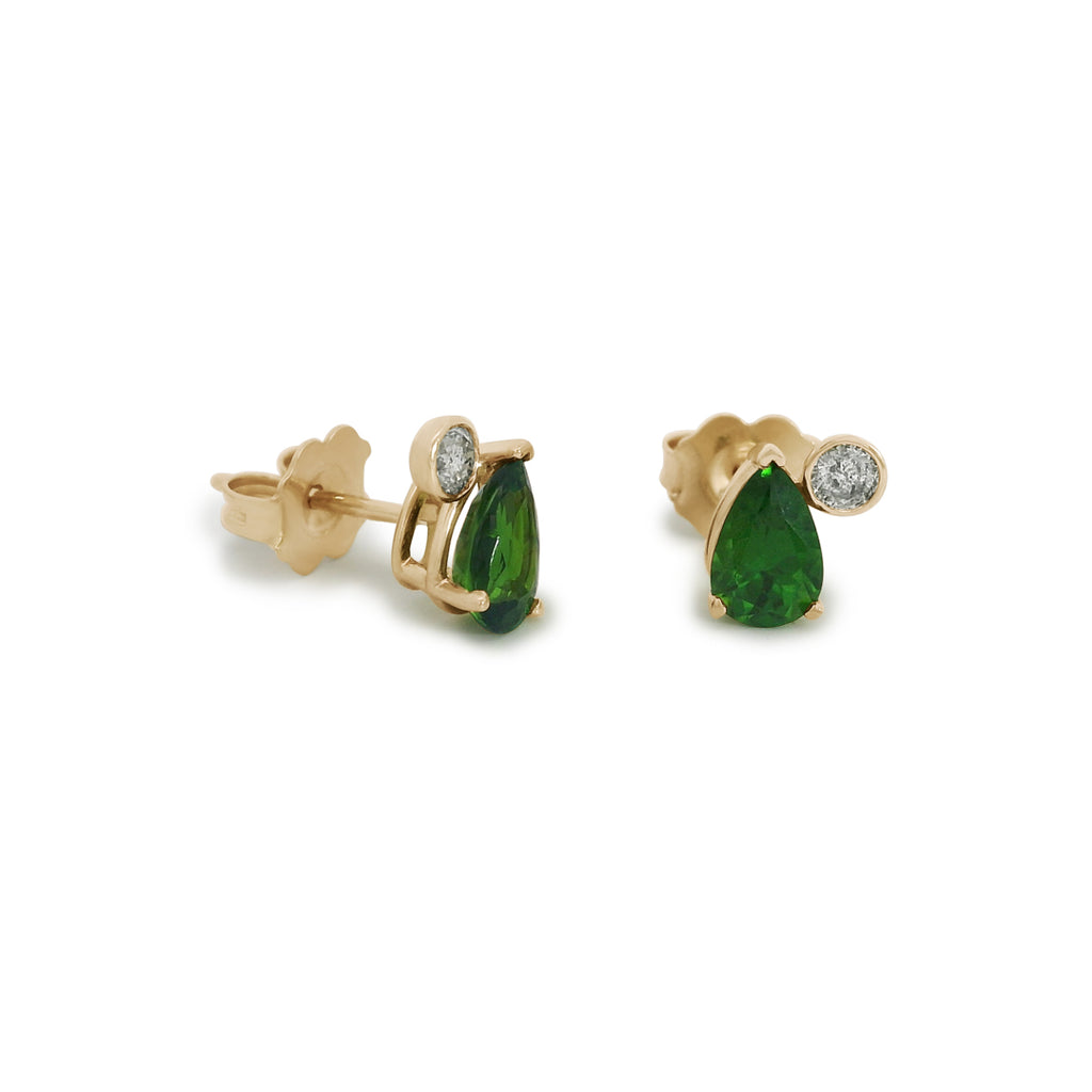 Pair of green pear cut chrome diopside stud earrings with round grey diamonds set in yellow gold on a white background