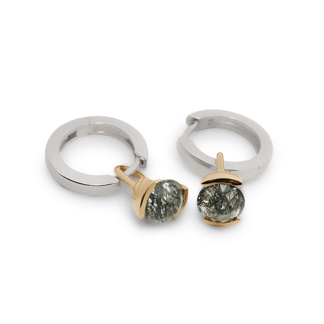 Pair of silver hoop earrings with gold drop details featuring inverted black rutile quartz on a white background