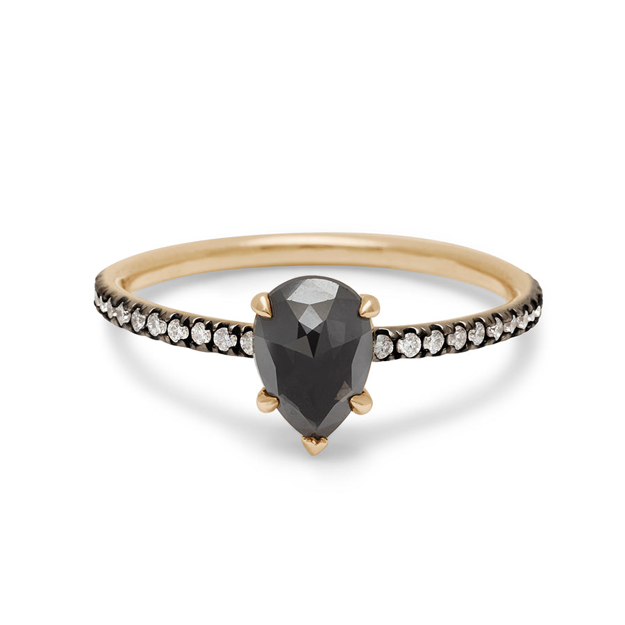 A solitaire pear shaped black diamond ring with claw prongs with white diamond pave on the band set in black rhodium and yellow gold.