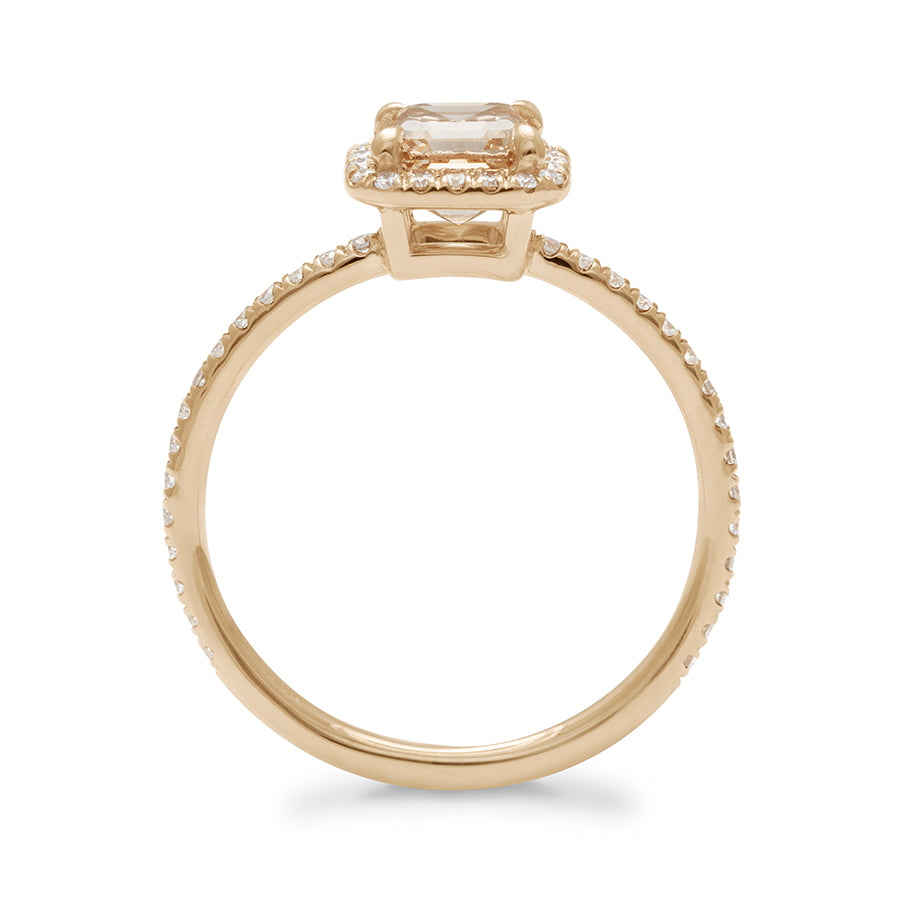 Side view of an engagement ring with an asscher shaped champagne diamond center stone surrounded by a white diamond pave halo set in yellow gold with white diamond pave on the band.