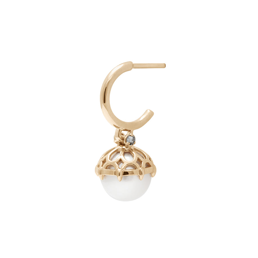 Angled view of a single hoop with a white pearl hanging from it with grey diamond accents on either side set in yellow gold.