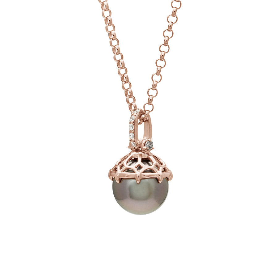 Angled view of a one of a kind peacock pearl pendant with white diamond pave on the top and grey diamond accent stones on either side on a rose gold chain.