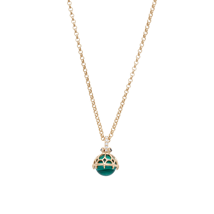 Zoomed out view of a one of a kind malachite pendant with white diamond pave on the top and grey diamond accent stones on either side on a yellow gold chain.