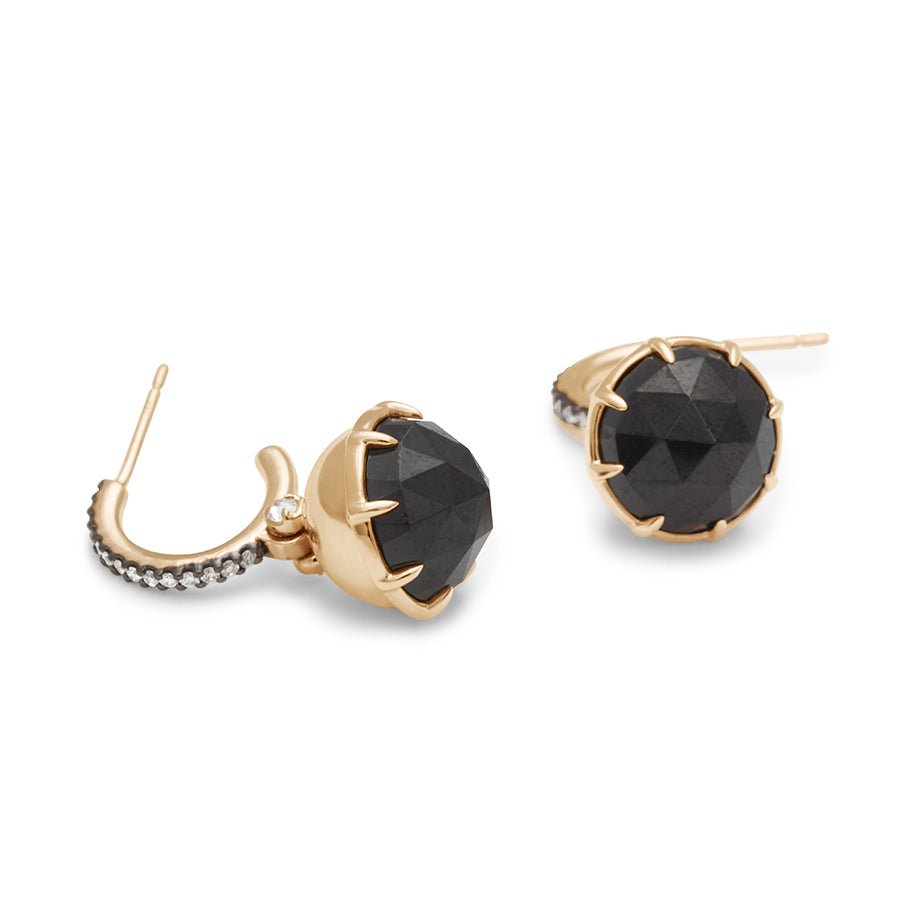 Side view of a pair of drop hoops with a black spinel hanging from them with white diamond accents on either side set in yellow gold with white diamond pave set in black rhodium.