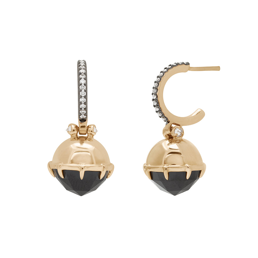 A pair of drop hoops with a black spinel hanging from them with white diamond accents on either side set in yellow gold with white diamond pave set in black rhodium one earring angled.