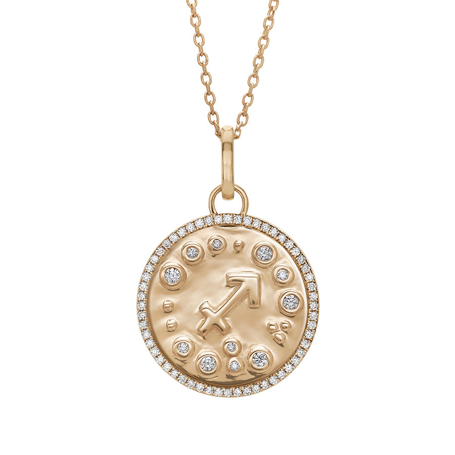 A 19mm constellation charm pendant with a Sagittarius sign in the center with white diamond accent stones and a white diamond halo set in yellow gold on a yellow gold chain., Sagittarius