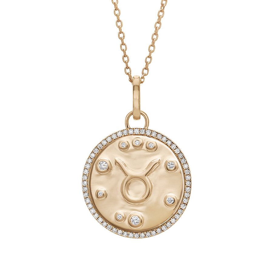 A 19mm constellation charm pendant with a Taurus sign in the center with white diamond accent stones and a white diamond halo set in yellow gold on a yellow gold chain., Taurus
