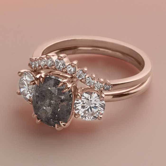 Three stone engagement ring with grey diamond center and white diamond side stones.