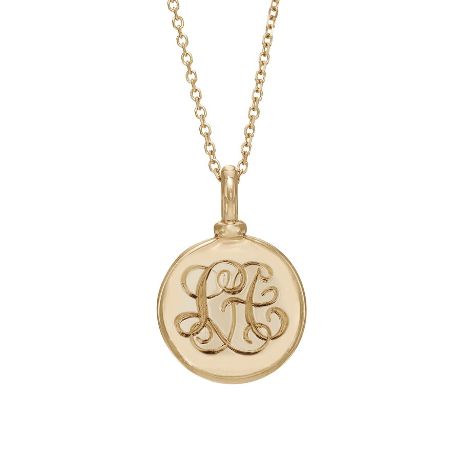 A 18mm charm with interlocking monogrammed engraved on the front set in yellow gold on a yellow gold chain.