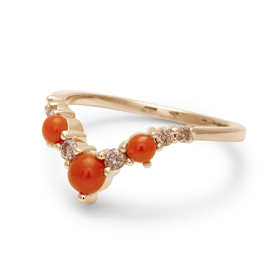 Angled view of a band with three large coral stones with champagne diamonds in between set in yellow gold., Yellow Gold