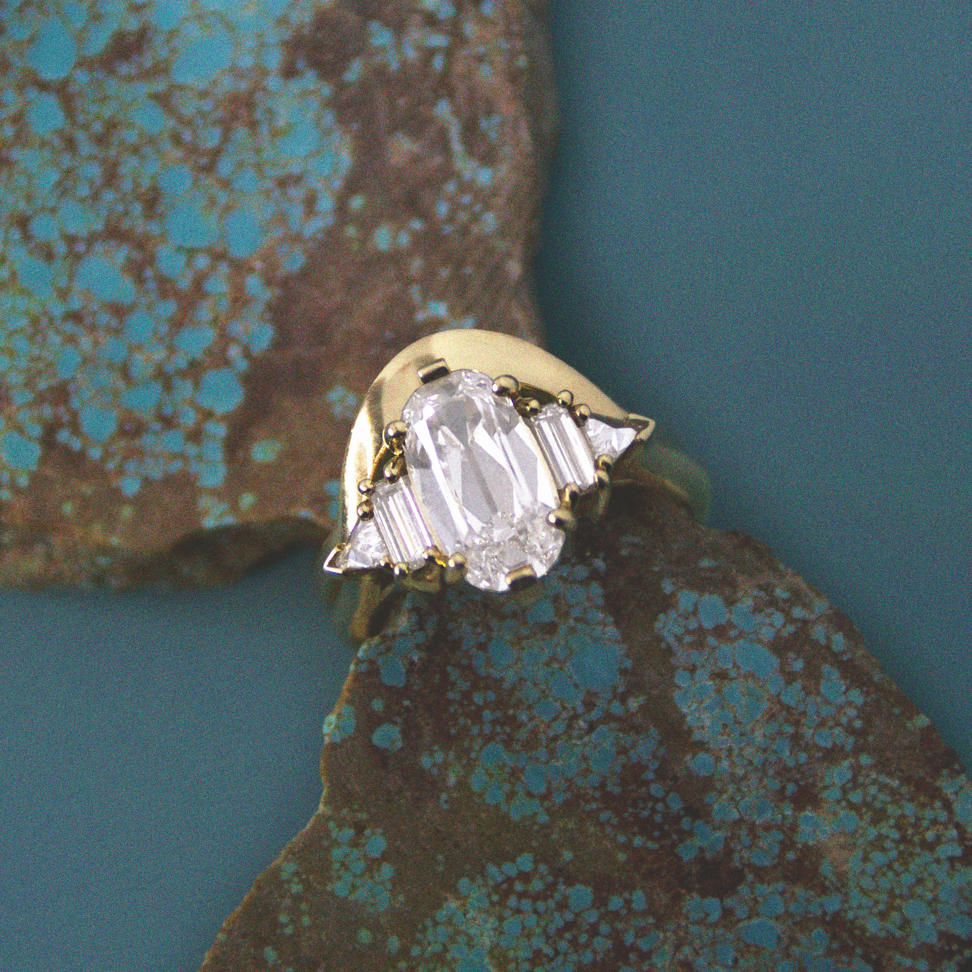 white diamond engagement ring sitting on turquoise by anna sheffield