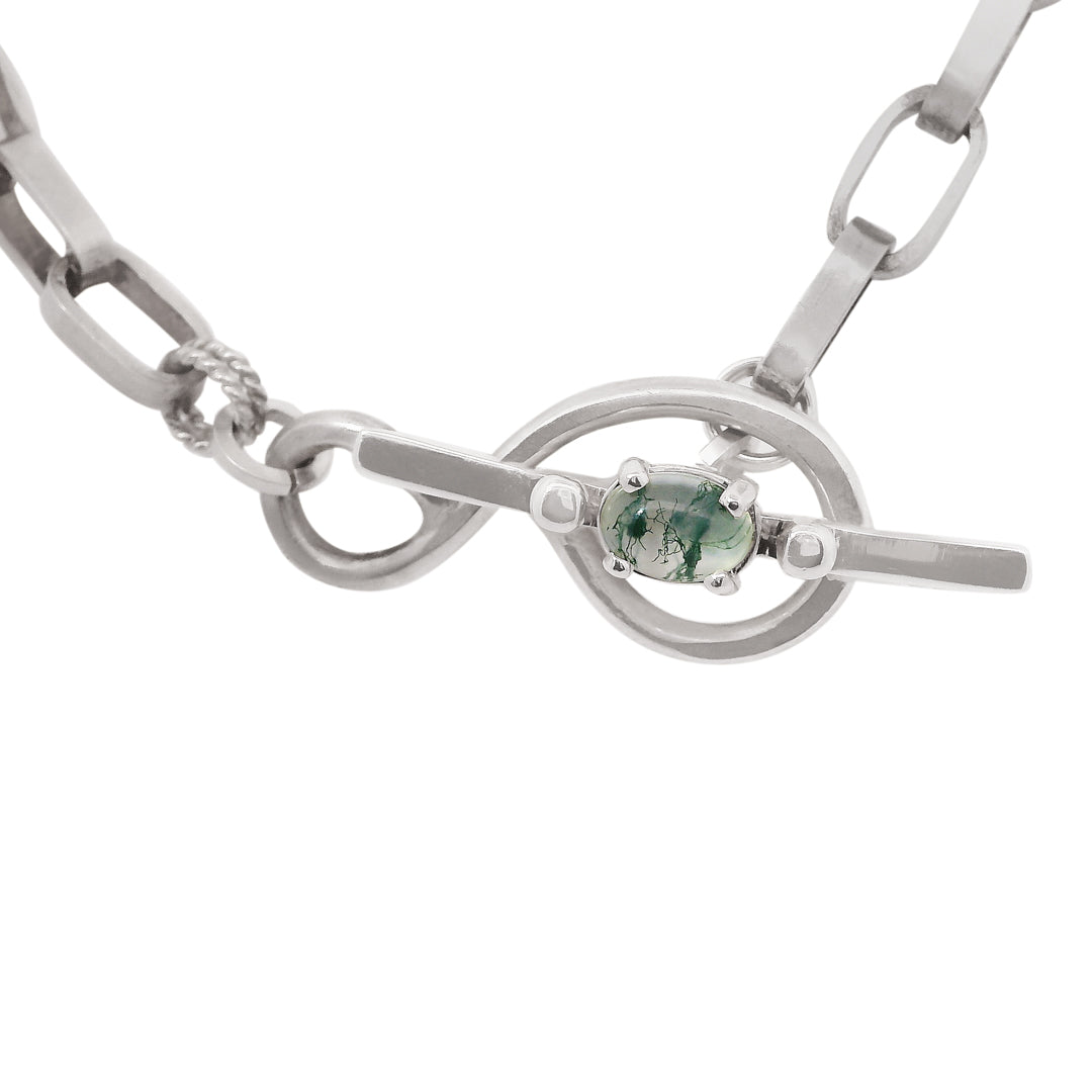 Silver chain necklace with a green moss agate gemstone on a white background