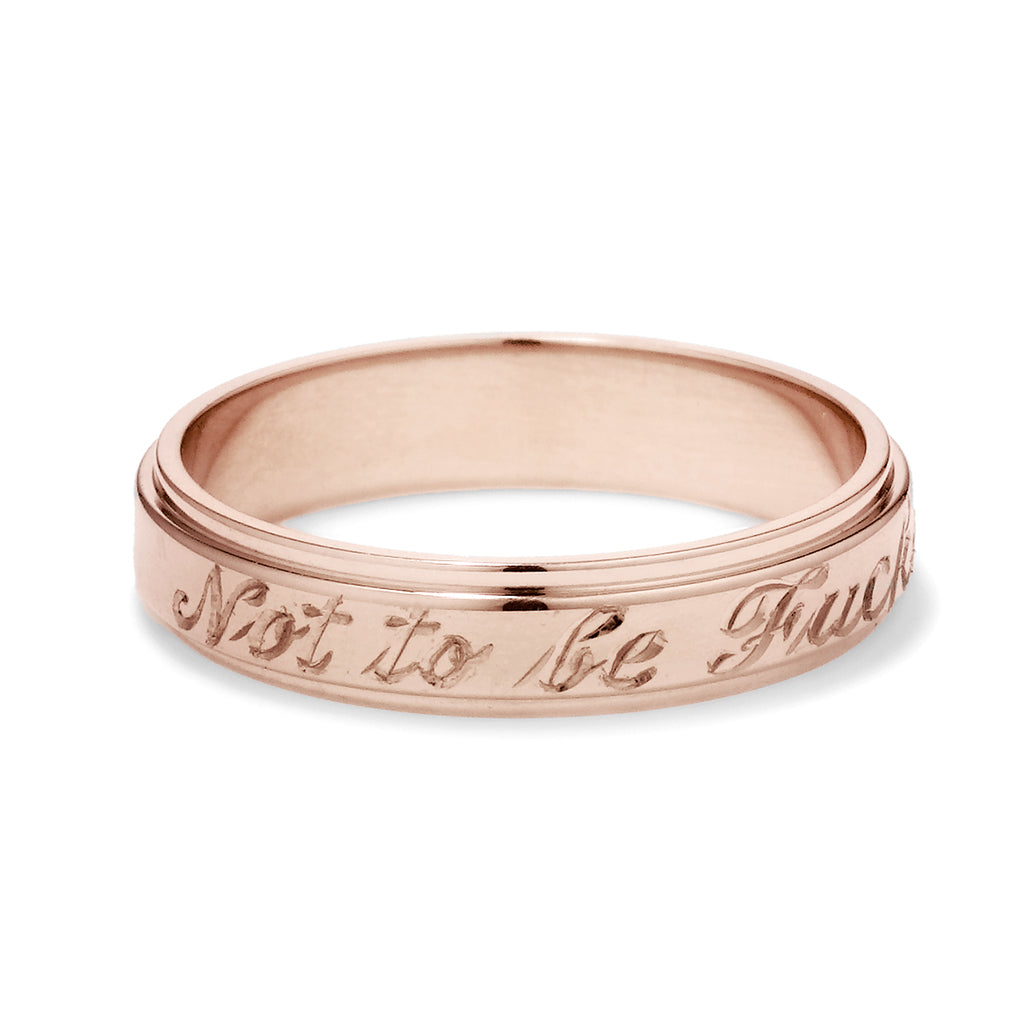 A rose gold flat edge band in 3mm with "Not to Be F**ked With" engraved on the outside.