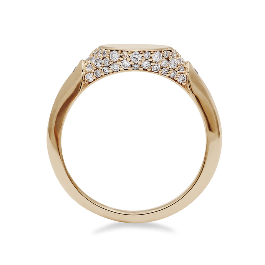 Side view of a solid gold signet ring with two white diamond accents on either side and a pave set around the top of the ring and set in yellow gold.