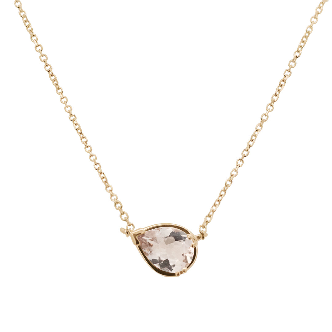 A delicate gold chain necklace featuring a teardrop-shaped pale pink gemstone in a gold bezel setting, displayed against a solid white background.