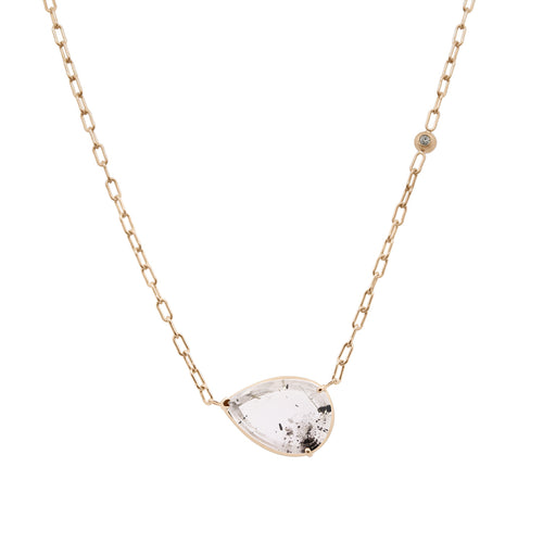 Gold necklace with a teardrop-shaped clear gemstone on a white background