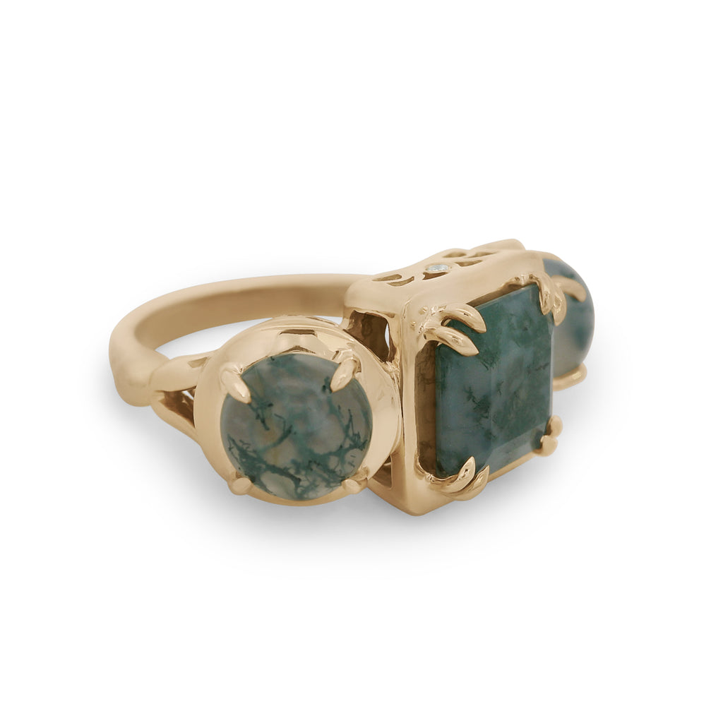 Gold ring with green gemstones on a white background