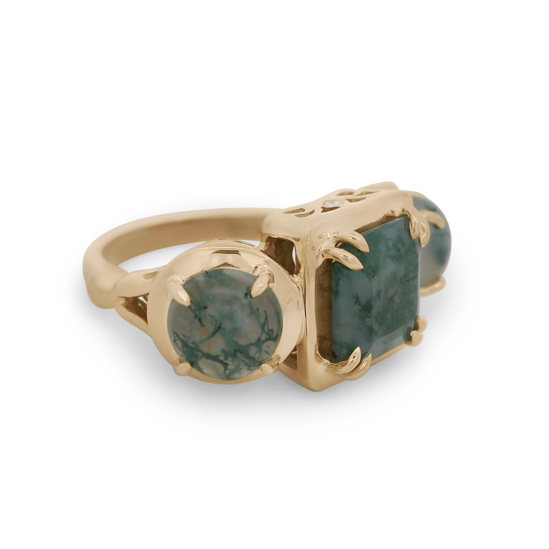 Gold ring with green gemstones on a white background