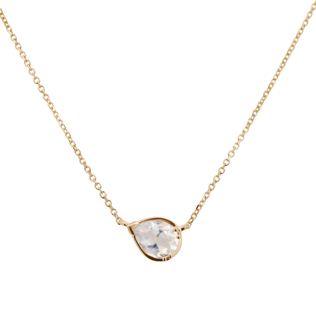 Zoomed in view of a necklace with a pear pendant with a rainbow moonstone set in yellow gold with a yellow gold chain.